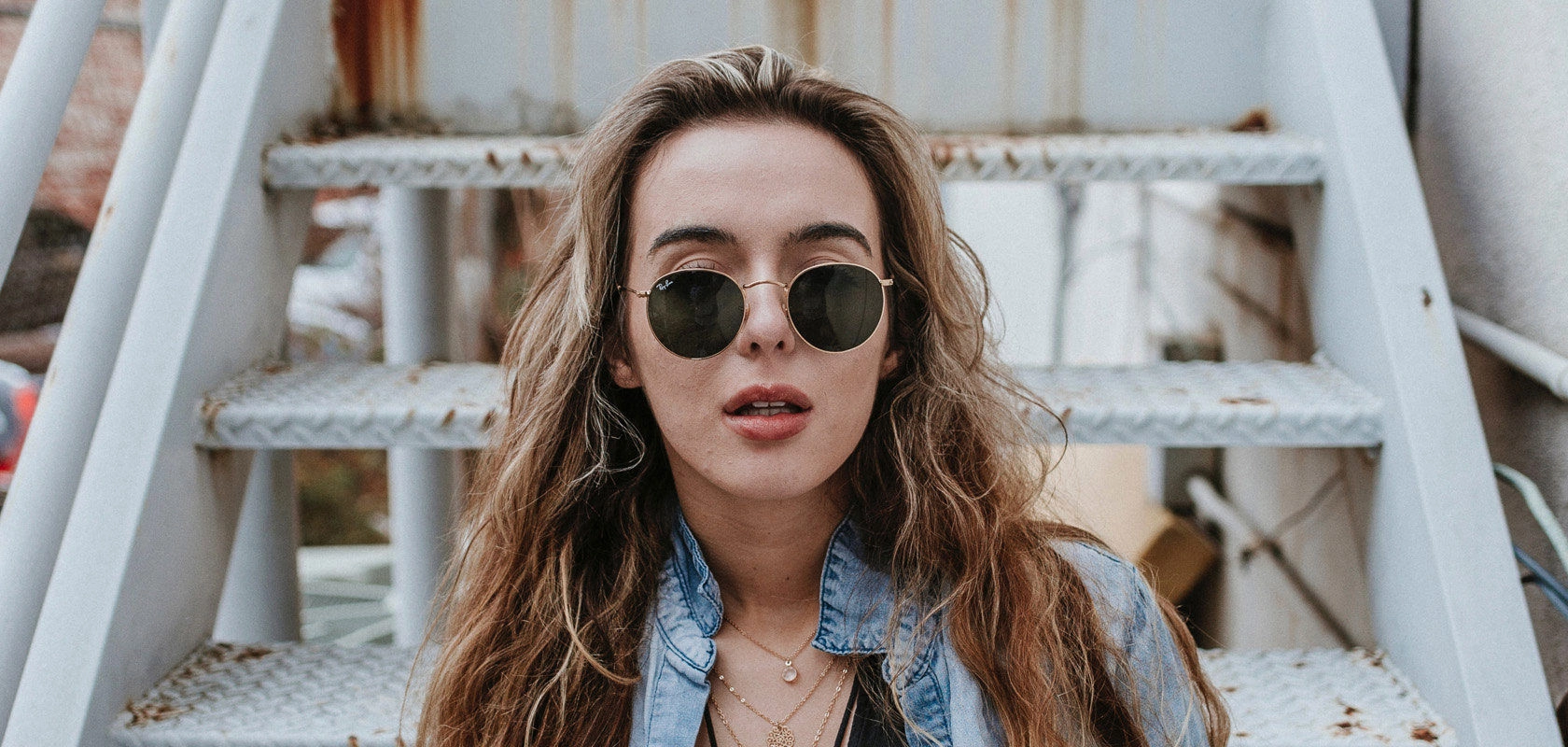 Mujer con lentes de sol redondos y cristales oscuros