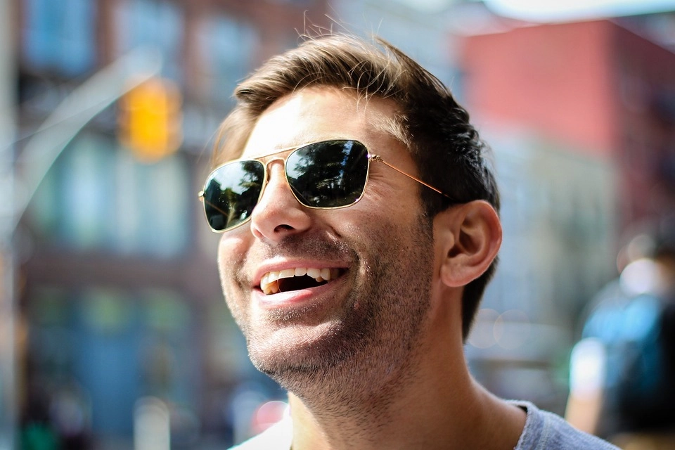 Hombre feliz con lentes de sol y cristales oscuros